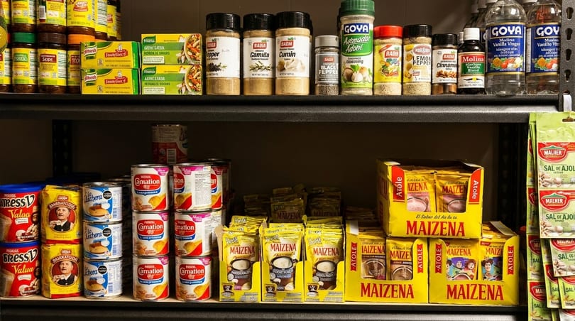 A pantry shelf filled with various spices, canned goods, and boxed food items.